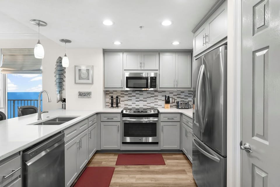 Modern kitchen with stainless steel appliances and ocean views.