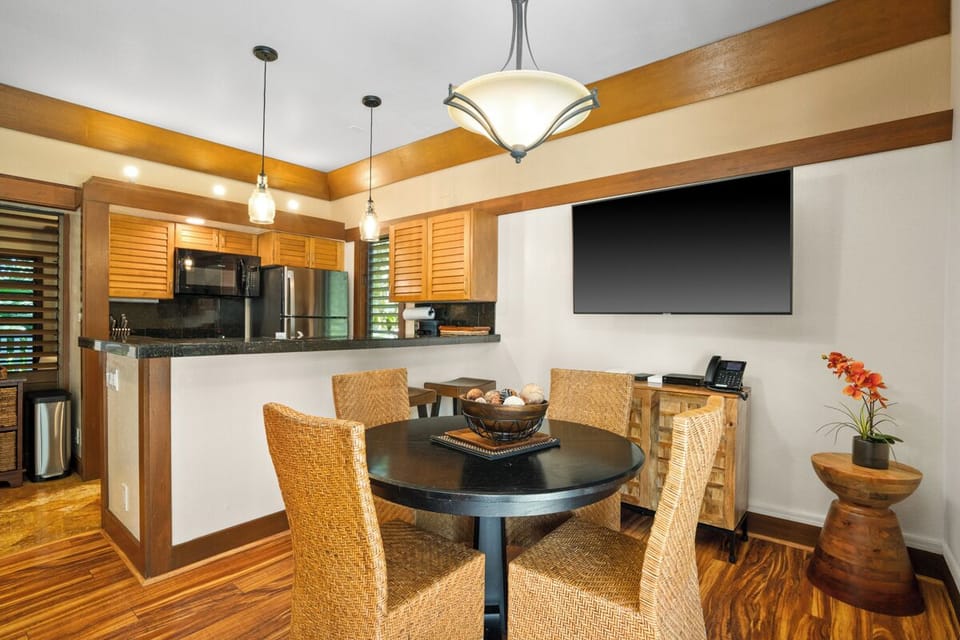 Gather around your inviting dining table, where warm wood tones and modern kitchen amenities create the perfect spot for memorable meals and easy conversation throughout your stay.