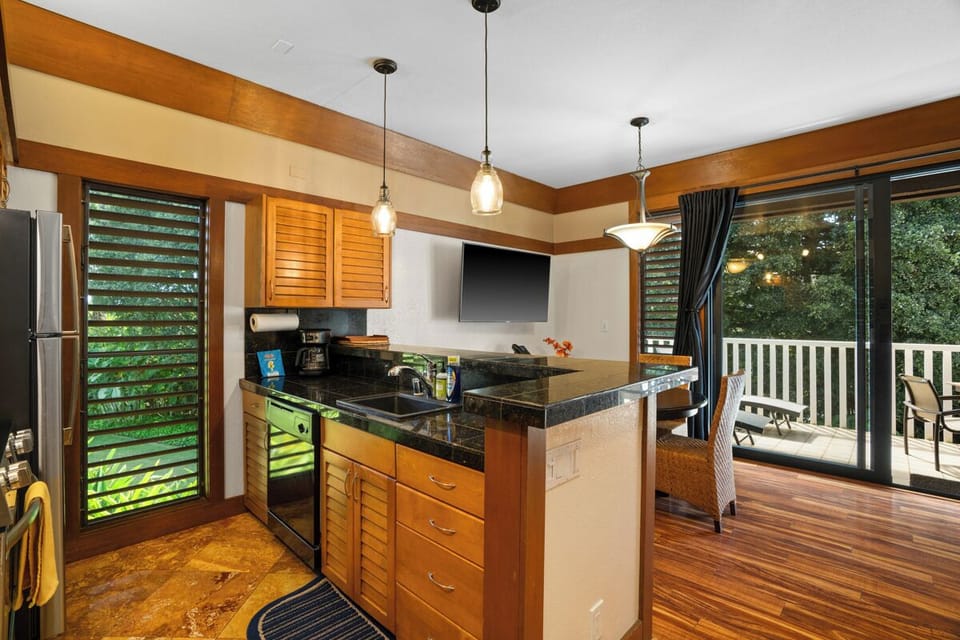 Your beautiful kitchen opens onto a private deck surrounded by lush greenery, perfect for morning coffee or evening meals with a serene forest view right outside.