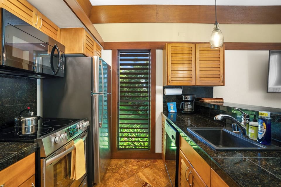 Your fully equipped kitchen features granite countertops, stainless steel appliances, perfect for preparing tropical meals during your stay.