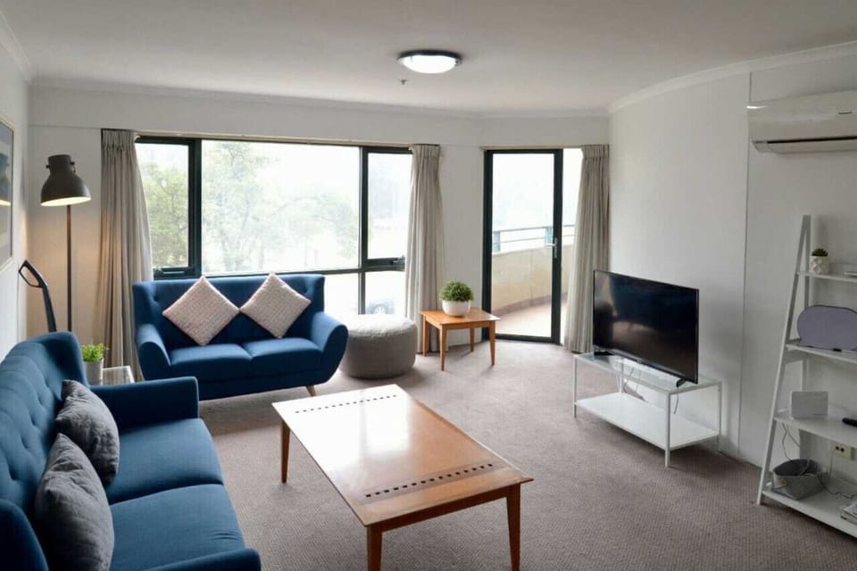 The lounge room offers a cozy and inviting atmosphere, featuring plush blue sofas that provide a perfect spot to relax and unwind. The combination of comfort and style creates a welcoming space for guests to enjoy.