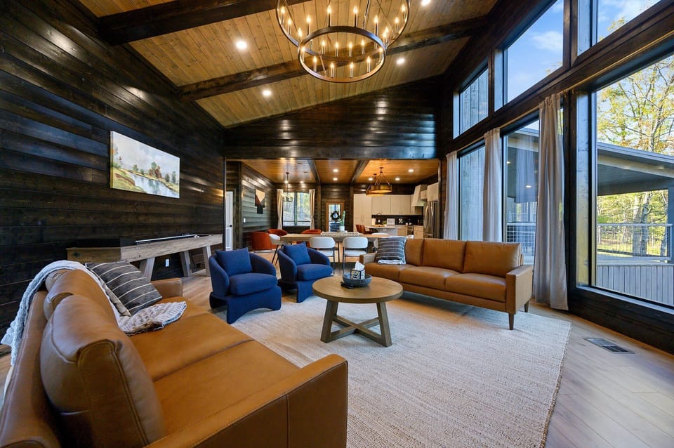 Tall ceilings, warm leather seating, and natural light pour into this open-concept living area — where family time just feels effortless.