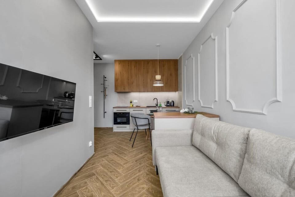 Living Room Area with Comfortable Fold-out Sofa and TV | Book Now with RENTUJEMY.COM