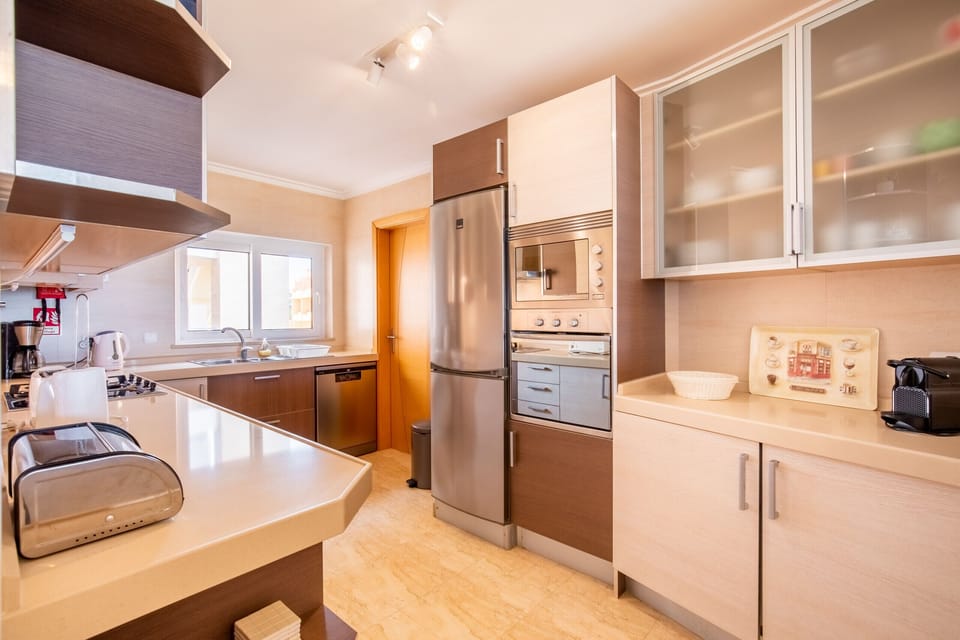 Modern and fully equipped kitchen with spacious countertops and quality appliances. The breakfast bar creates a practical area for quick meals, maintaining the flow of the space and the connection to the living room and balcony with sea views. Ideal for preparing meals in comfort and enjoying the company of those in the living room.