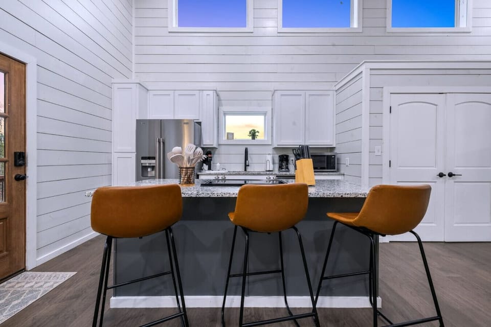 Slide onto one of those cognac-colored stools, lean against the granite countertop, and realize this kitchen island is basically the unofficial headquarters for the whole trip.