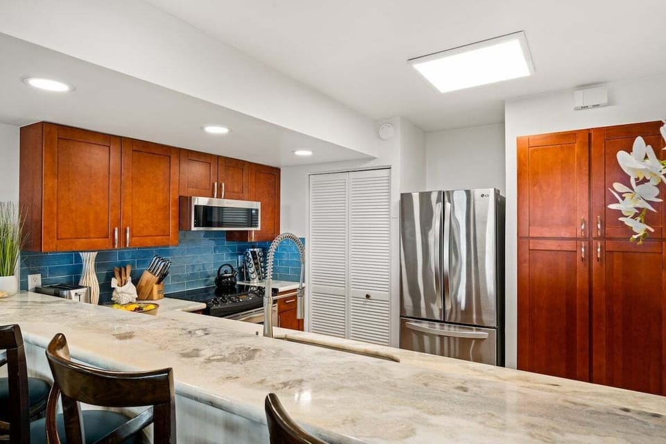 Contemporary kitchen featuring stainless steel refrigerator, ample storage, and sleek design for a chef-friendly experience.