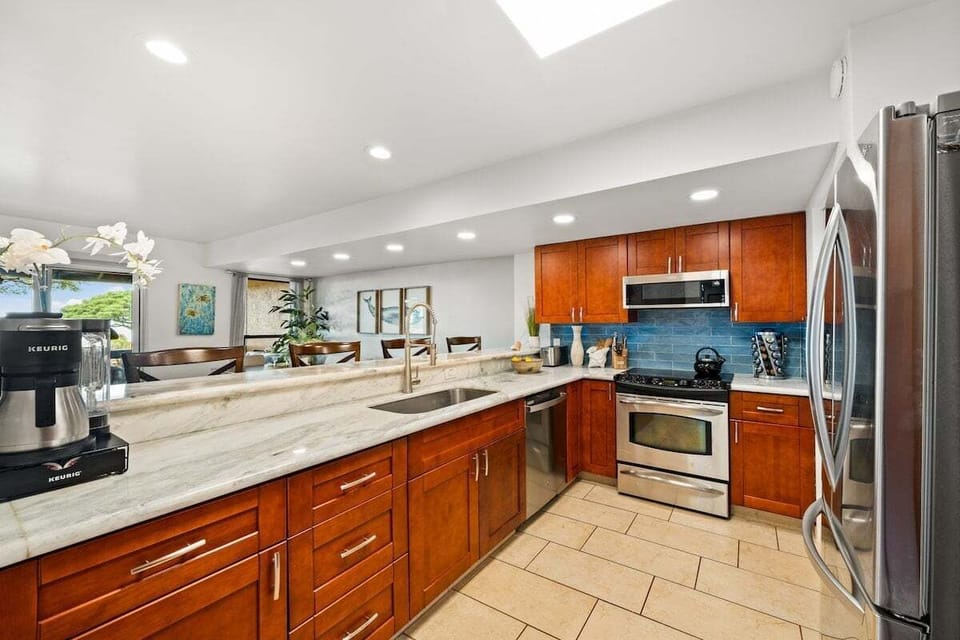 Fully equipped kitchen with modern appliances, wooden cabinetry, and spacious countertops for easy meal preparation.