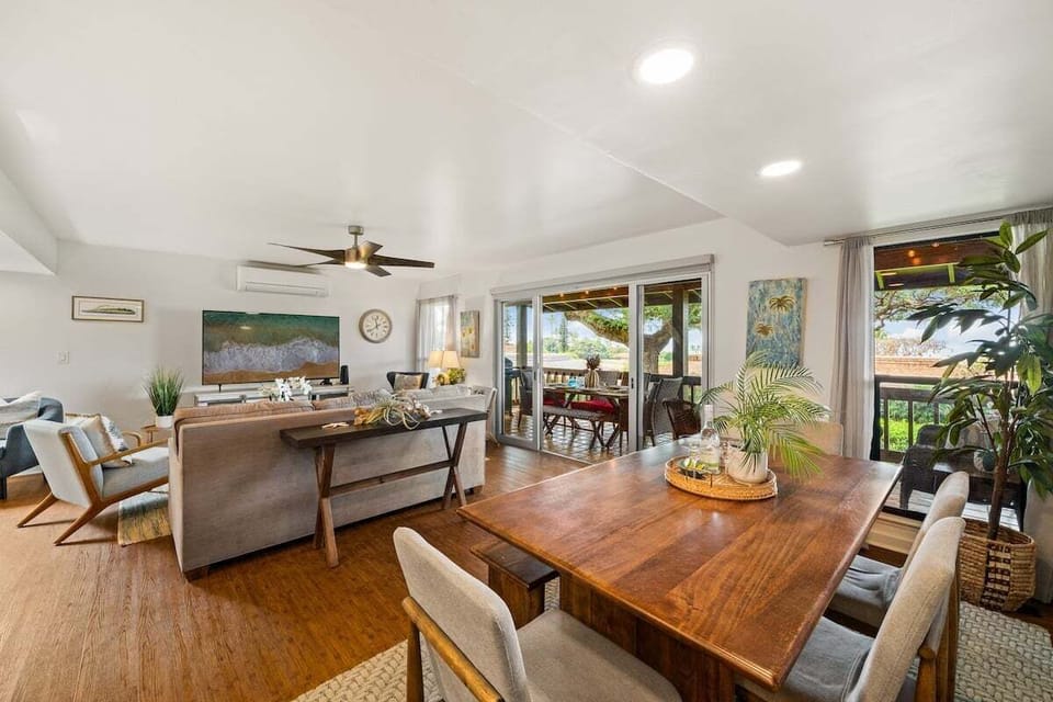 Elegant dining space with wooden table and seating for six, surrounded by windows for a bright and airy atmosphere.