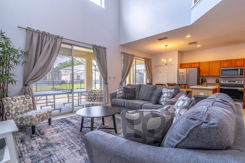 Open two story living area with access to the kitchen and private pool & Spa
