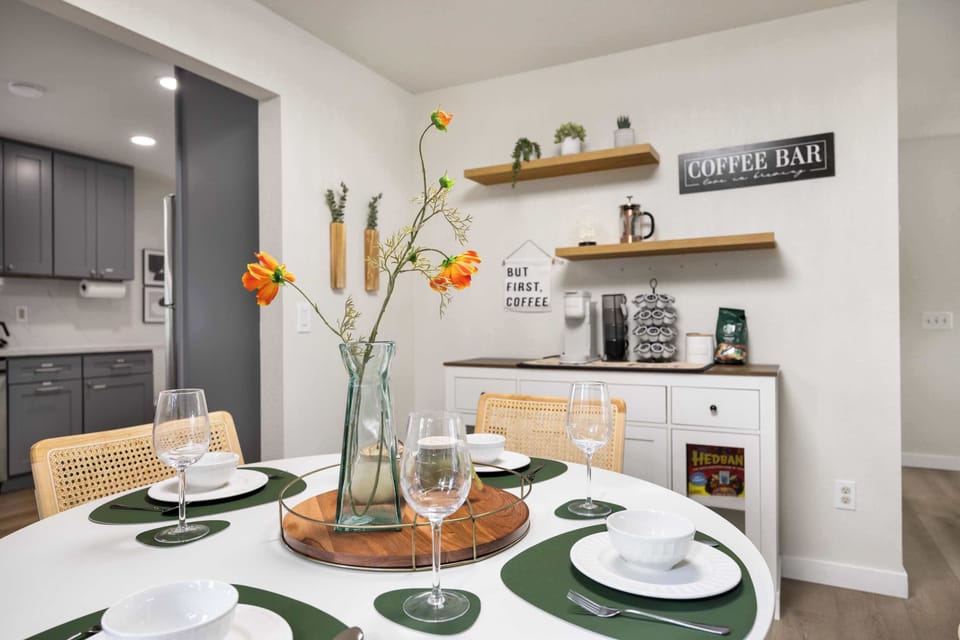 Embrace the perfect start to your day with our charming dining and coffee corner. The dining table, set with elegant dishware and vibrant floral accents, offers a warm space for meals.