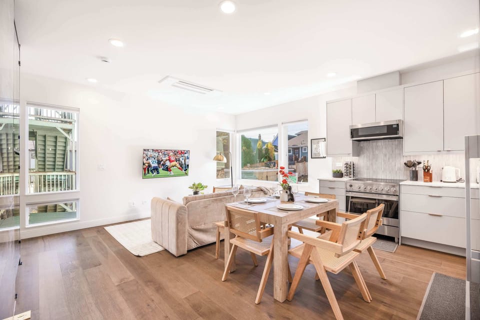The living room offers a comfortable space to relax, seamlessly connecting to the dining area with a stylish table for meals. Adjacent is the kitchen, equipped with modern appliances and a functional design for easy cooking and entertaining.