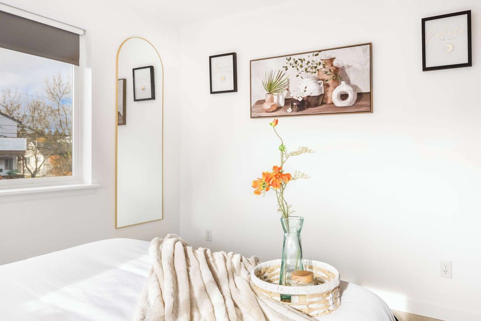Bedroom 2 features a stylish mirror that adds depth and brightness to the space, complemented by tasteful wall decorations that enhance the room's cozy and inviting ambiance.