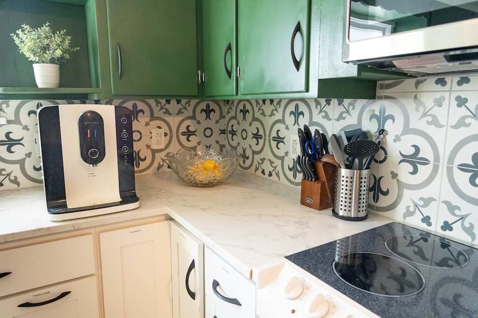 A selection of knives and utensils displayed in a countertop organizer, complementing a clean cooking area.