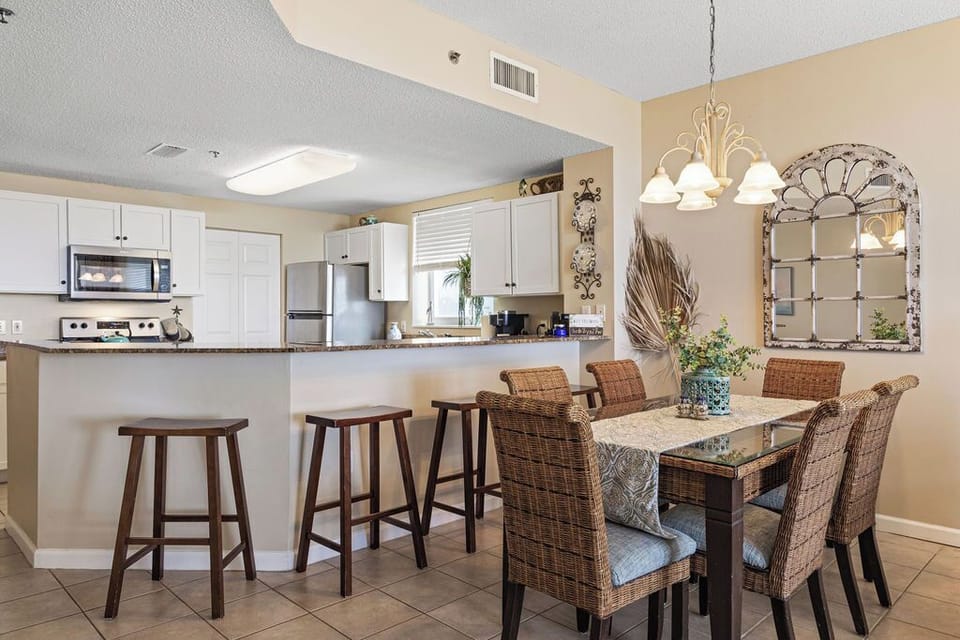 Dining Area - The open dining area features a table with seating for 6, with additional seats offered at the adjacent bar.