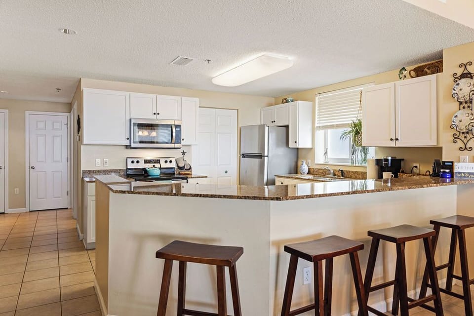 Kitchen - The kitchen features a large, eat-in bar with seating and is perfect for serving a buffet style meal.