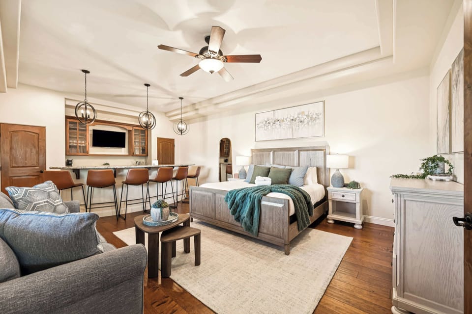 Bedroom 5 - Ensuite. Smart TV, Mini-Fridge, Coffee Nook, Bartop and Barstools, Double Closet. Blackout Curtains, Closet.  Recharge in bright comfort. Discover your ideal retreat: sleep, socialize, and unwind here.