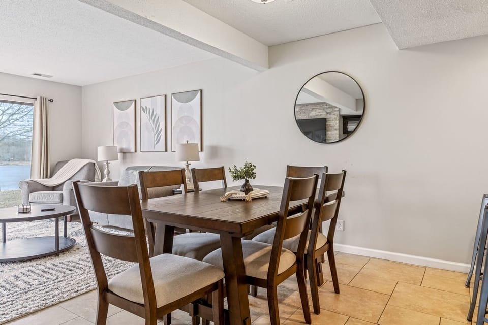 Six-seat dining table positioned between the kitchen and lake-facing living area.