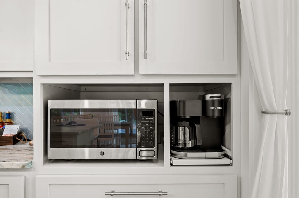 Sleek modern kitchen with built-in microwave and Keurig, perfect for brewing.