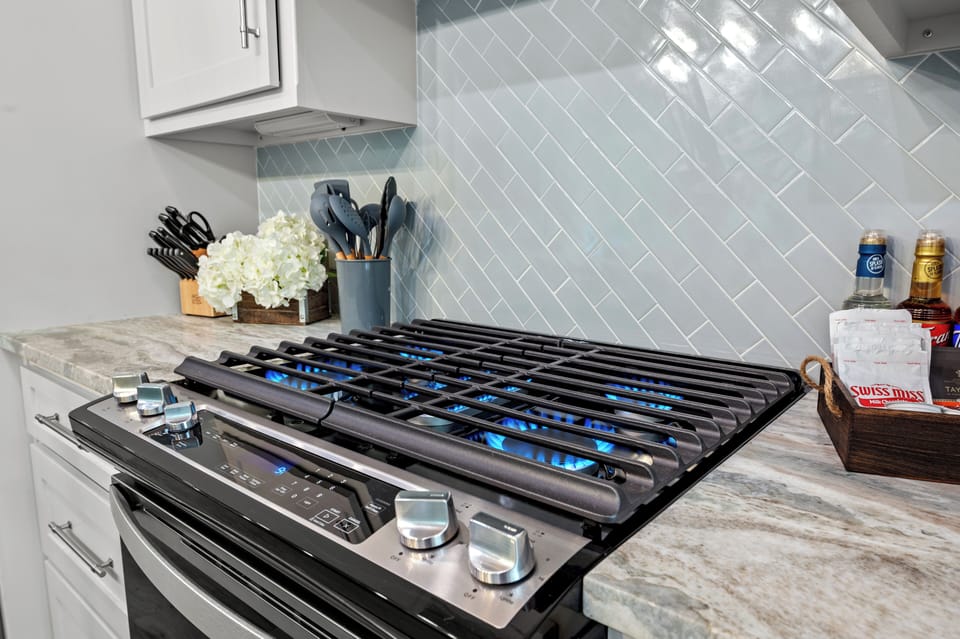 Cook in style with a sleek gas stove, marble countertop.