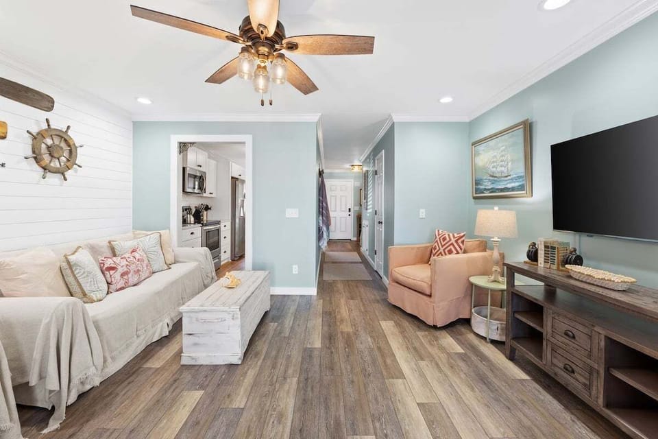 Cozy living room that features a big screen smart TV & a sleeper sofa.