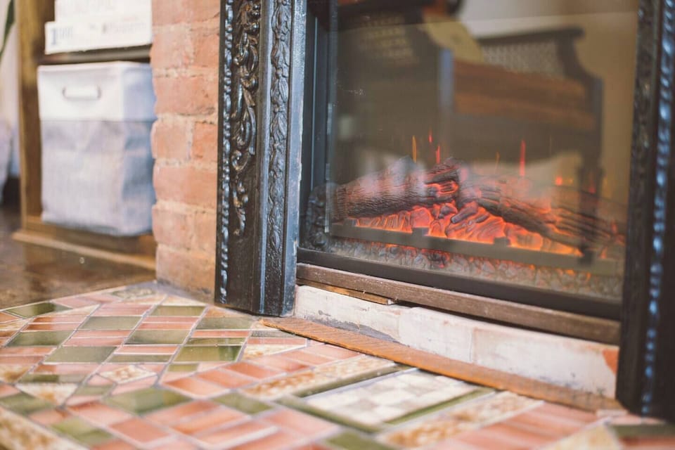 Gather around the cozy electric fireplace and admire the upcycled historic hearth