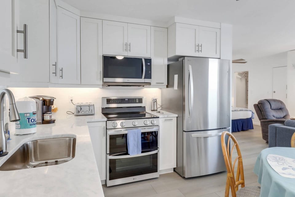 The remodeled kitchen features elegant finishes and upgraded appliances, including a double oven, microwave, and refrigerator/freezer.
