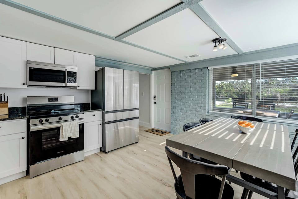 A modern kitchen and dining space featuring sleek appliances, ample seating, and a bright, airy atmosphere—perfect for enjoying meals together.





