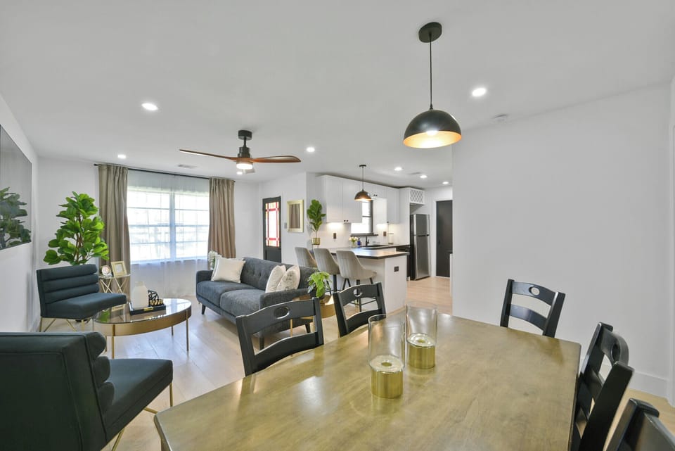 Unwind in the open-concept living room, featuring a sofa, smart TV. Ideal for gatherings, with board games and ample seating, creating a welcoming space for everyone to relax and connect. View from dining area.