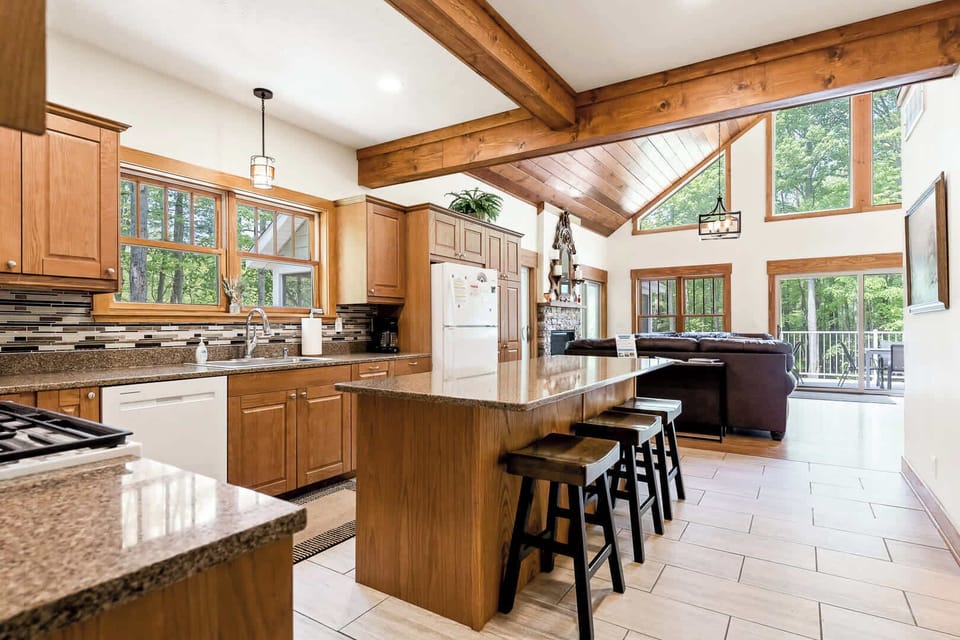 View of the Scott Creek Lodge living room and backyard, as seen from the well equipped kitchen