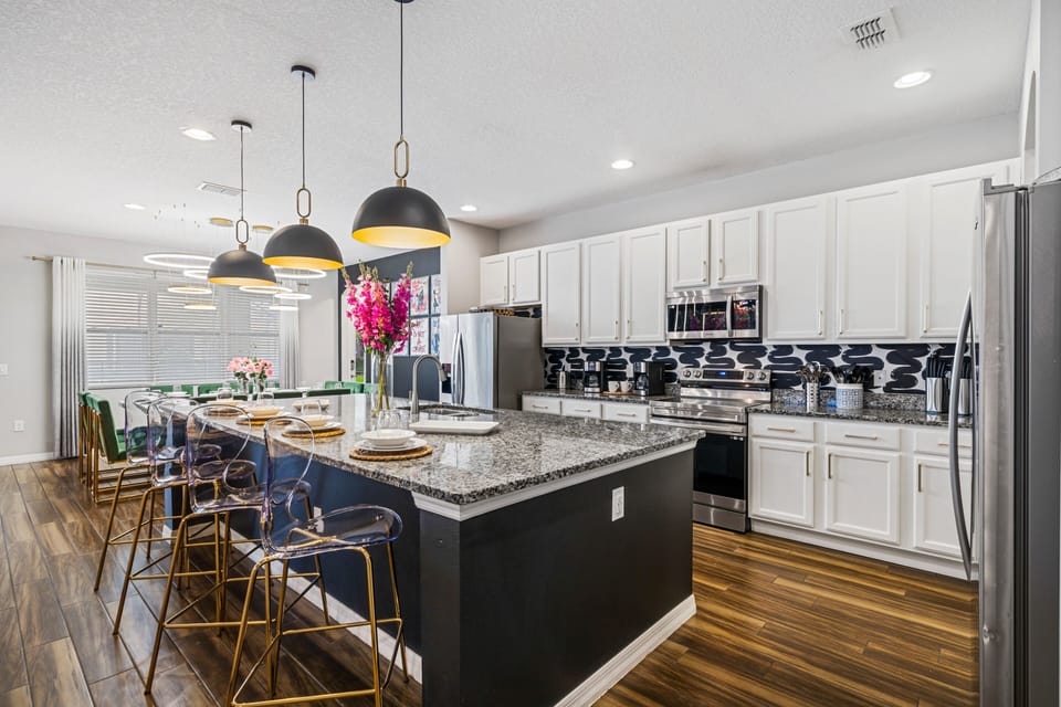 - Spacious kitchen with granite counters and island  
- Stainless steel appliances with double oven setup  
- Pendant lights and bar seating for casual dining