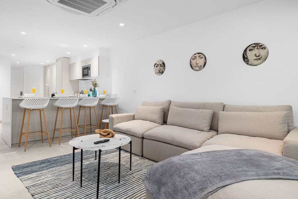 Unwind on your spacious sectional sofa while enjoying the open-concept design connecting your stylish living space to a sleek breakfast bar with modern seating.