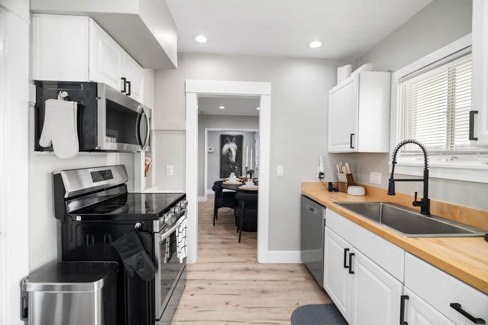A fully stocked kitchen with plenty of counter space, a large oven, and an electric cooktop, seamlessly blending 1908 charm with modern convenience.