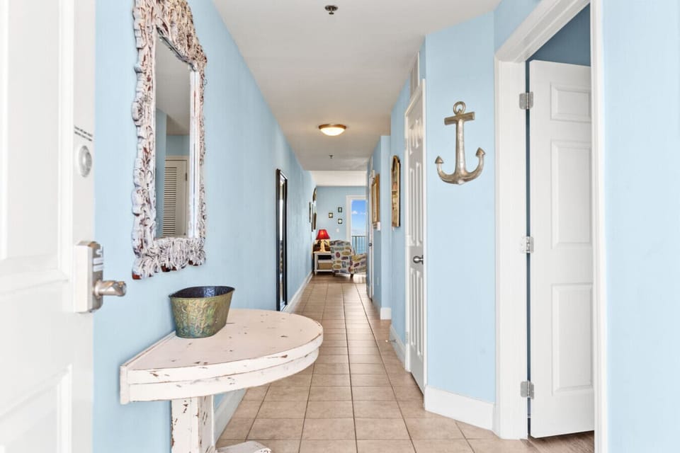 Spacious hallway with coastal decor leading to a bright living area with ocean views