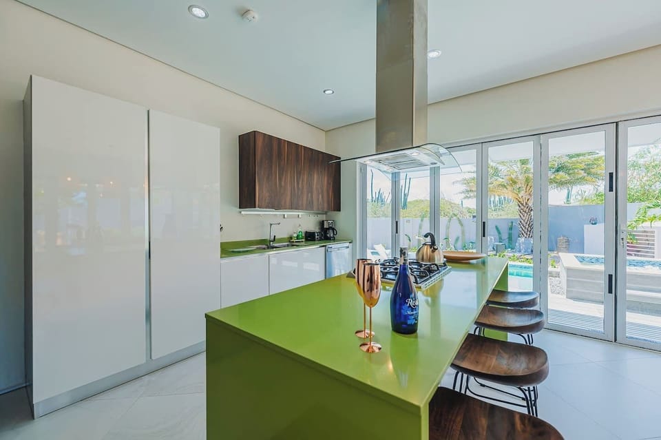 Spacious, fully equipped, and designed to bring people together—this kitchen is the heart of the home, even your home away from home. With bar seating for entertaining and a perfect pool view, every moment here feels special.
