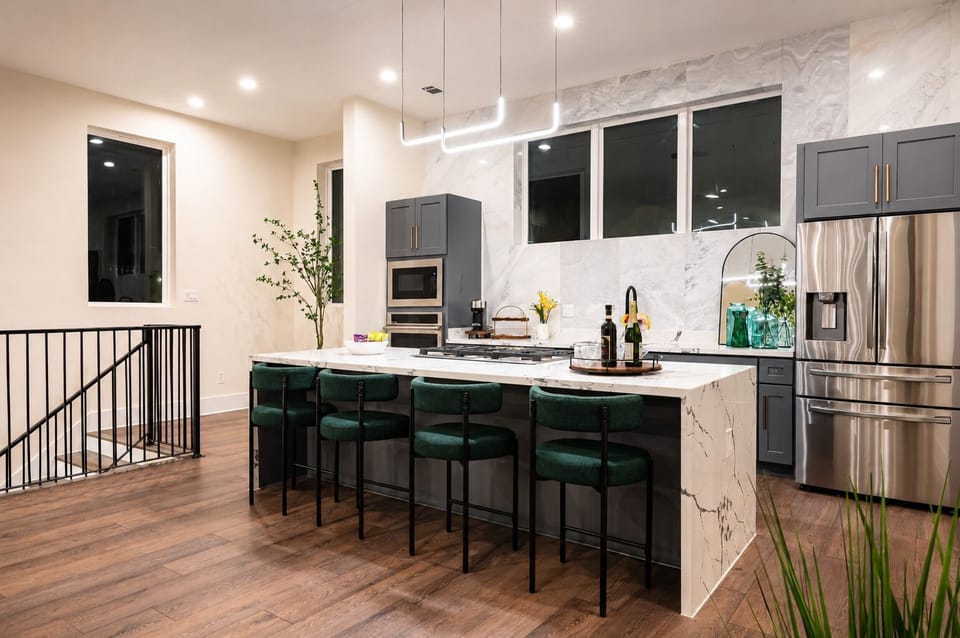Modern kitchen vibes fully equipped with monogram and high-quality appliance! Sleek design, comfy seating, and a gorgeous marble island. Perfect for entertaining!