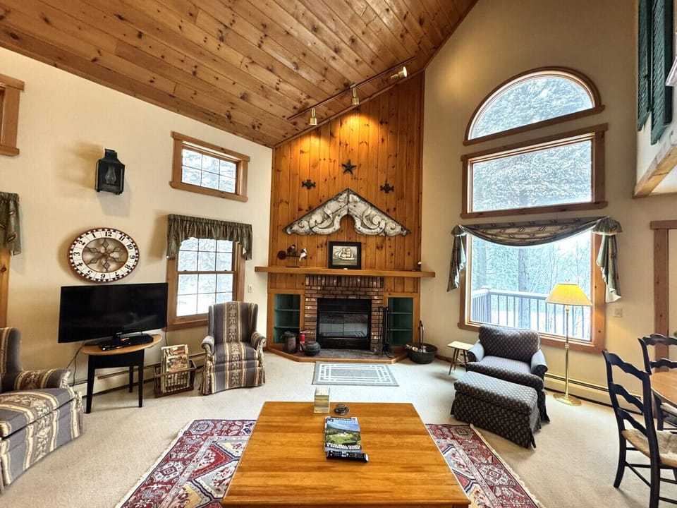 Opening Living room with wood burning fireplace and 50` TV