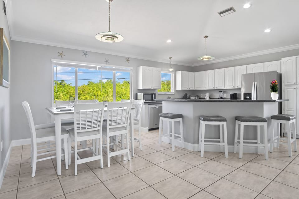 Beautiful dining area with tropical views, plus extra seating at the kitchen island — plenty of space for the whole group to gather and enjoy!