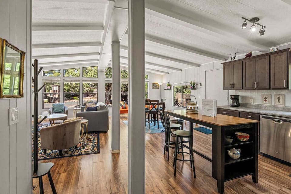 Cozy sunroom retreat with vibrant chairs and panoramic forest views.