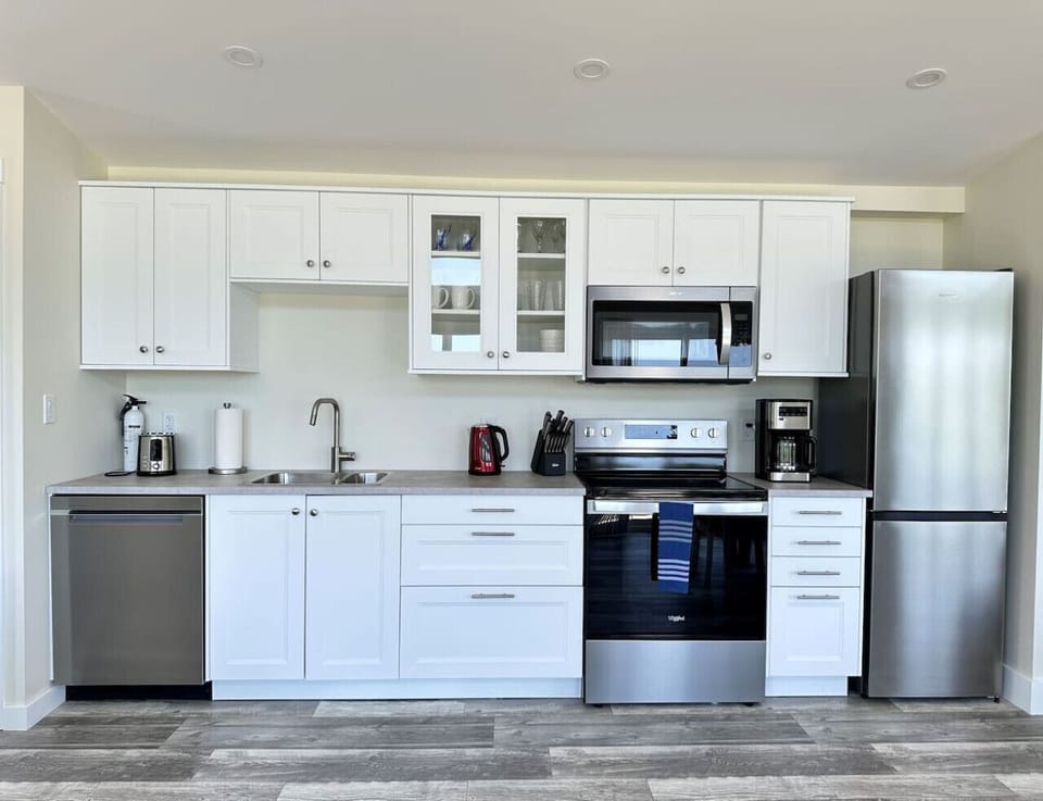 Full kitchen with stove, fridge, microwave, sink, dishwasher, coffee maker, toaster and kettle