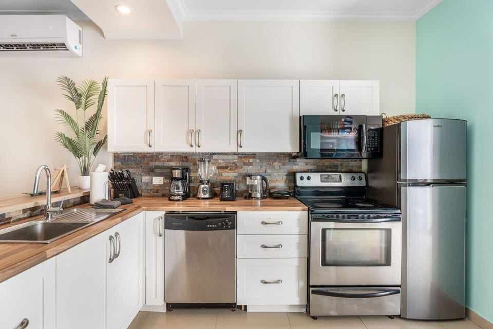 Cook with ease in the fully equipped kitchen featuring a stove, microwave, dishwasher, fridge-freezer, and coffee maker. Perfect for quick breakfasts or home-cooked meals during your Aruba vacation.