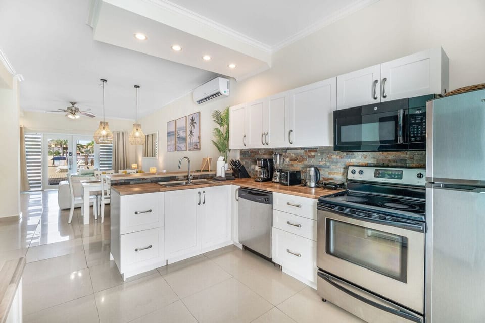 This modern kitchen has everything you need, including a blender, kettle, dishwasher, and full-size appliances. A functional and stylish space to fuel your beach days.