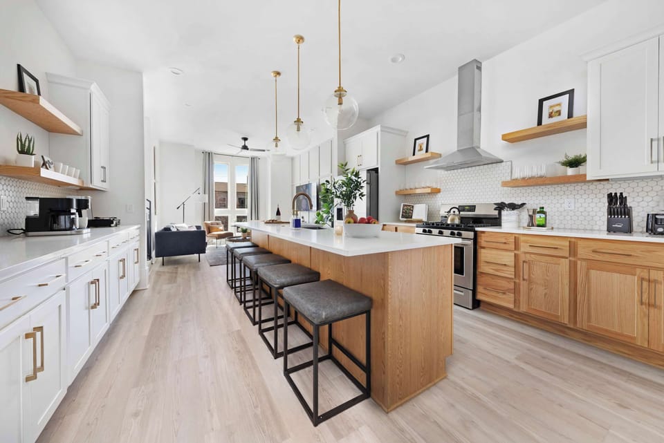 Modern kitchen with a spacious pantry and a large island with five barstools, ideal for cooking and casual dining