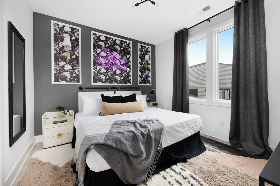 Spacious bedroom with a king bed, walk-in closet, and a dedicated workspace. The en-suite bathroom features a shower with dual access from both the bedroom and kitchen.