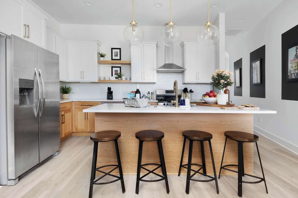 Clean and Spacious Kitchen with Sleek Countertops and Additional Seating