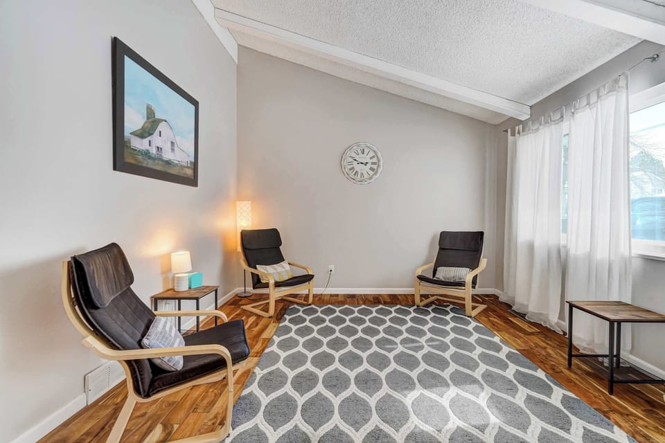 This cozy seating area offers a relaxing space to unwind, featuring stylish armchairs, soft lighting, and natural light streaming through large windows. Perfect for reading or enjoying a quiet moment. 

