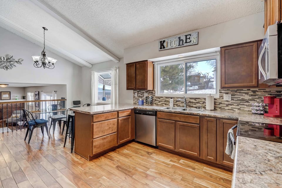 This spacious kitchen features sleek stainless steel appliances, ample counter space, and warm wood cabinetry. The open layout connects seamlessly to the dining area, making it easy to cook and entertain at the same time.





