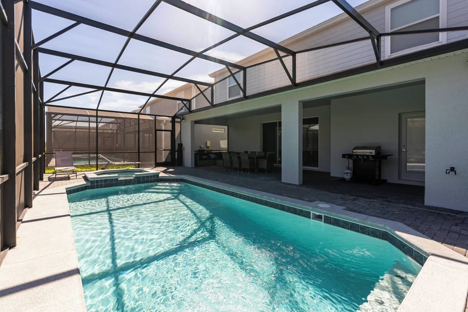 Step into your private oasis featuring a sparkling pool and spacious lounge areas. The sleek tile flooring enhances the natural light, while the screened enclosure ensures comfort and privacy for your relaxing afternoons.