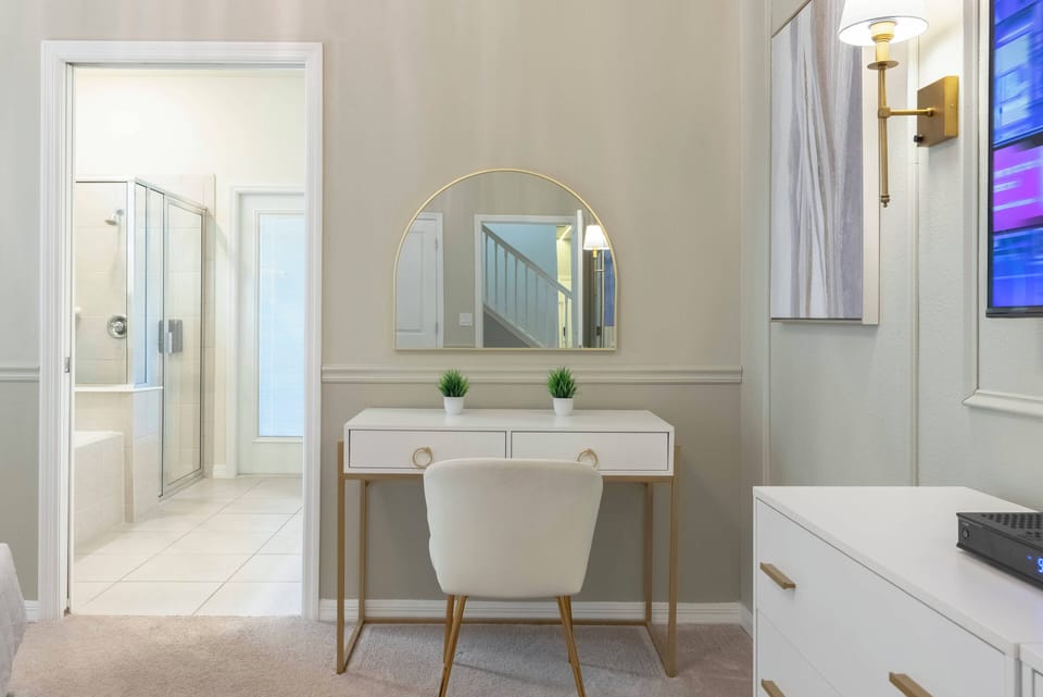 Welcome to a bright, stylish room with a chic vanity and round mirror, ideal for your morning routine. Soft neutral tones and modern lighting create a cozy atmosphere that invites you to relax and unwind.
