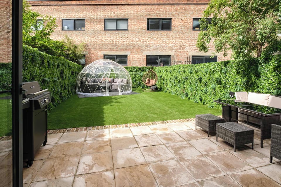 Garden | Escape to our private hidden gem garden, a true oasis of tranquillity, featuring an egg swing sofa, a dining table, a cosy seating area, and BBQ facilities for outdoor dining. Surrounded by greenery and softly lit with LED lights all around.