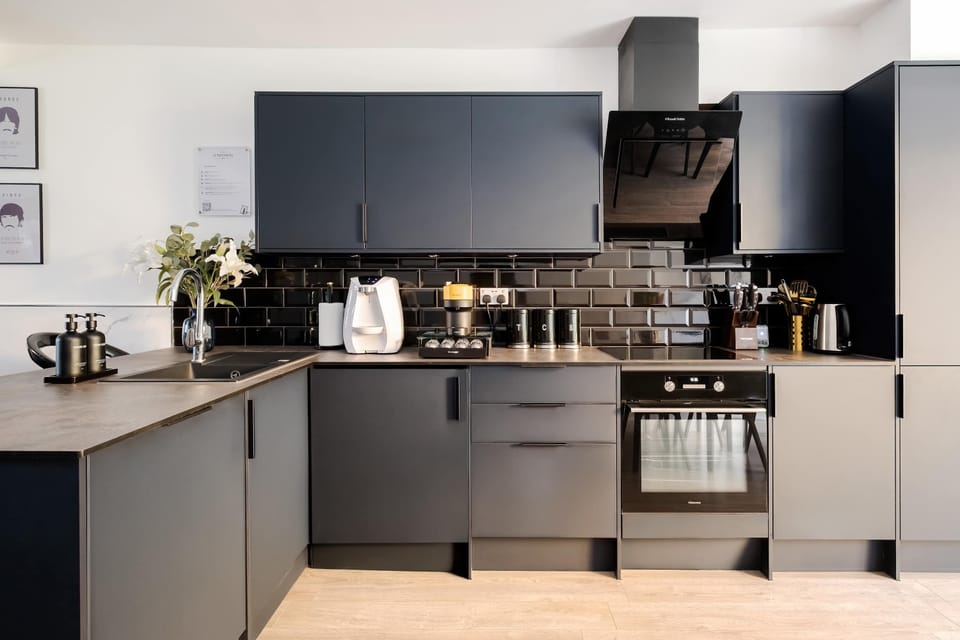 Full Kitchen | A kitchen fully equipped with everything needed for a comfortable stay, including a water dispenser, modern appliances, full cookware, and a dining table. The space flows directly into the private garden for a smooth and social layout.